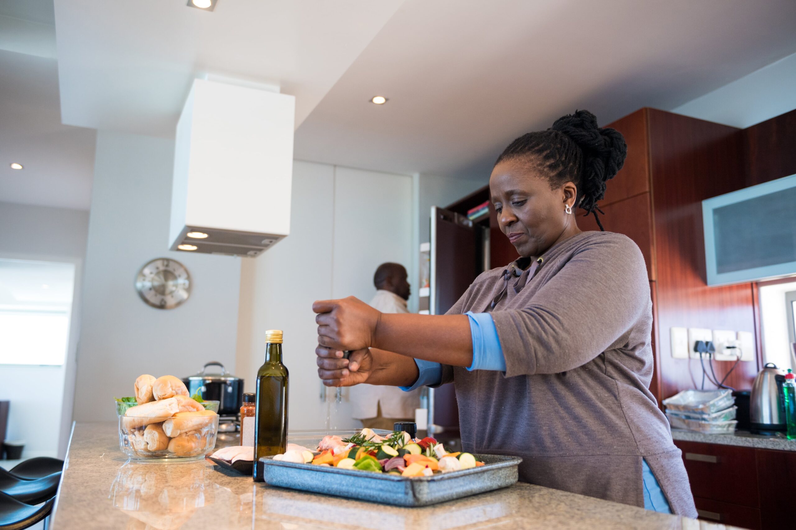 woman seasoning salad while preparing food at home